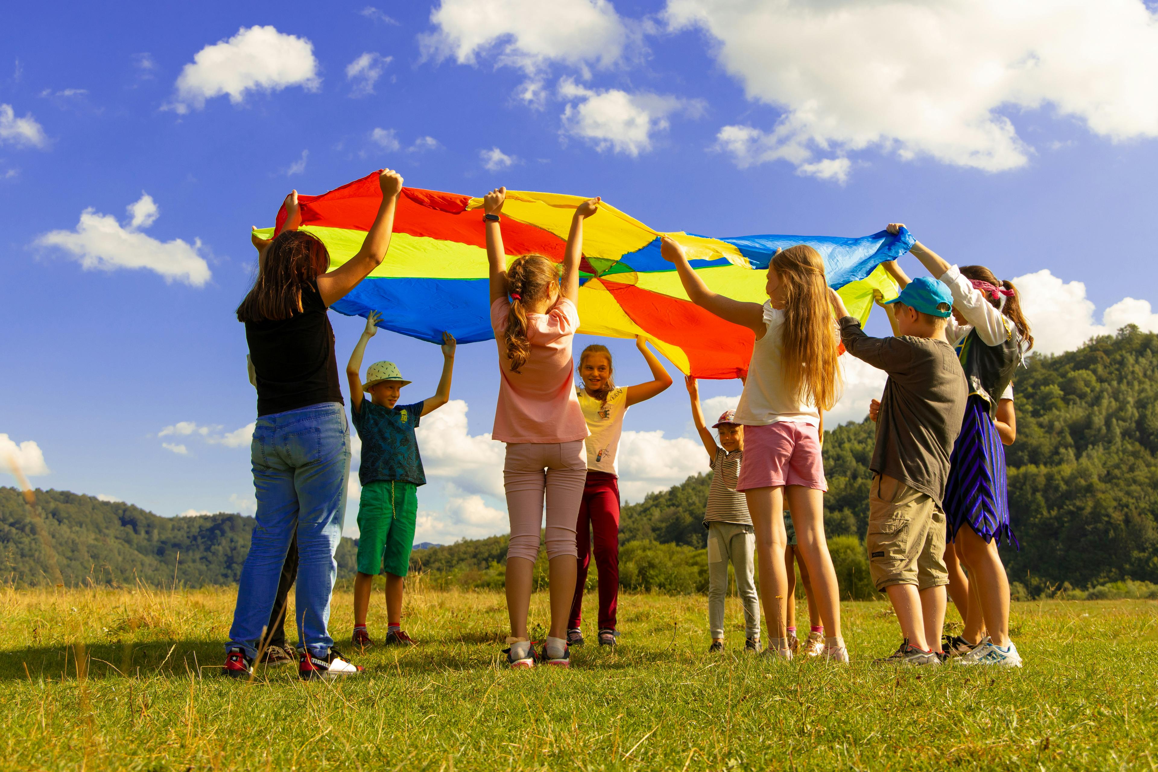 Children raising a flag in a green field